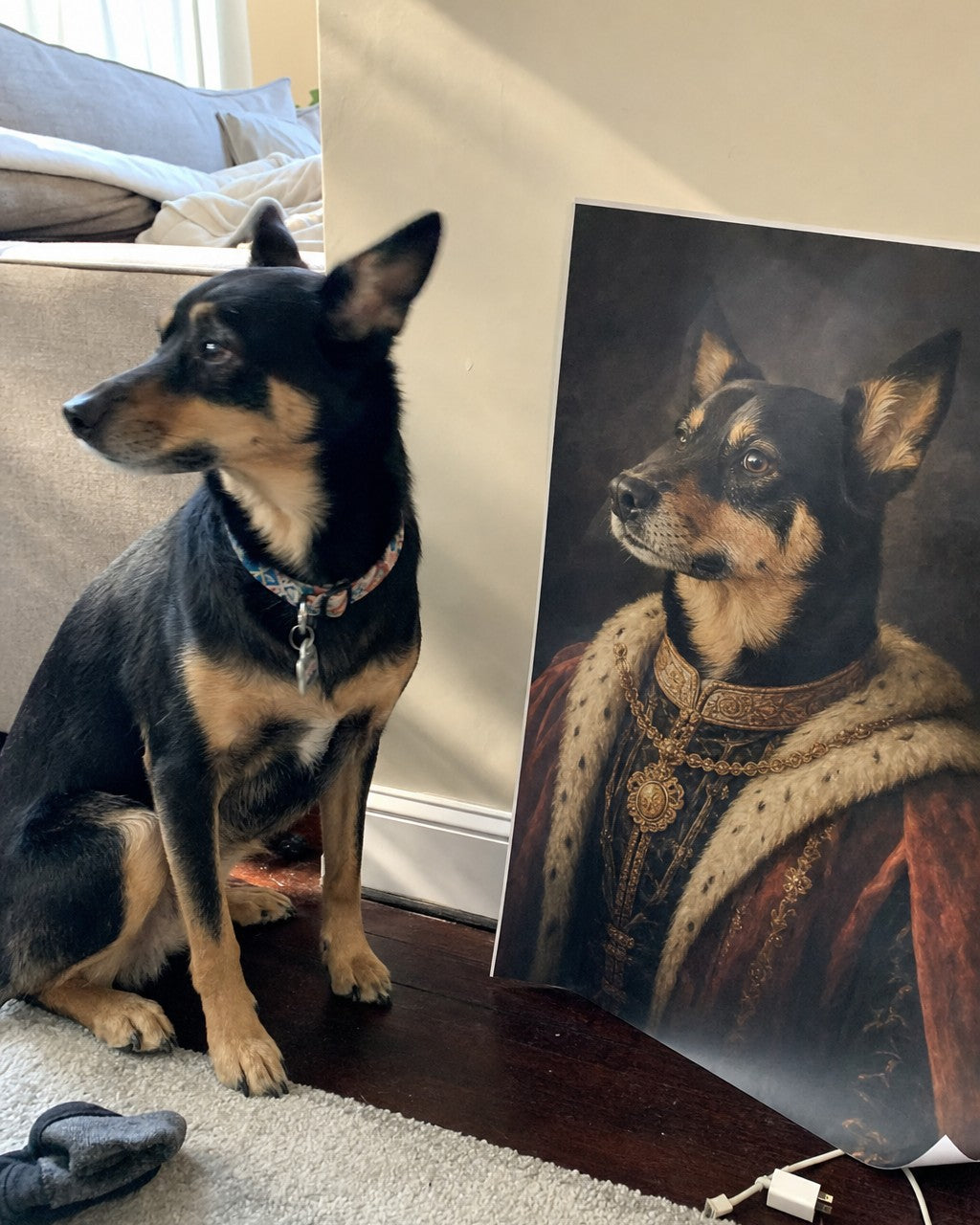 A golden retriever sitting next to its own renaissance royal portrait